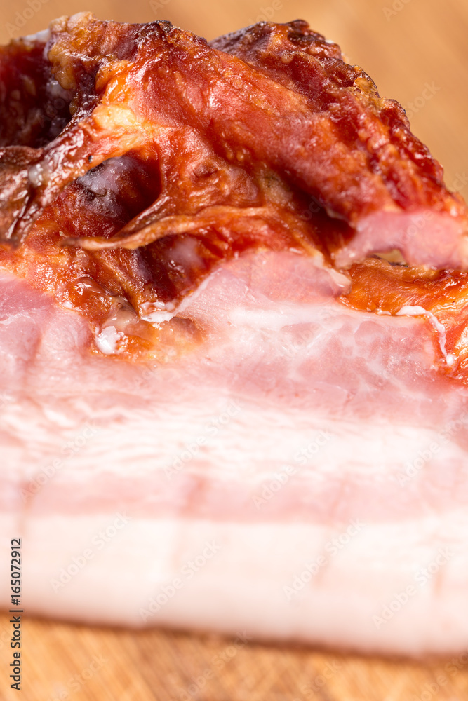 Raw homemade pork bacon on the round wooden board Raw homemade pork bacon on the round wooden board