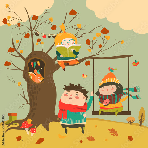 Happy kids ride on a swing in the autumn forest