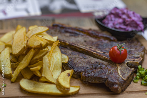 Steak with potato and salad served on a cutting board