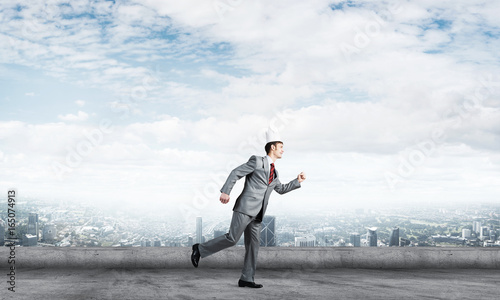 King businessman in elegant suit running on building roof and business center at background