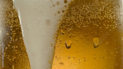 Glass of beer with froth and water drops in macro