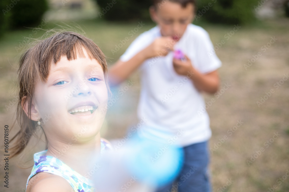 Close-up portrait of small girl blowing bubbles