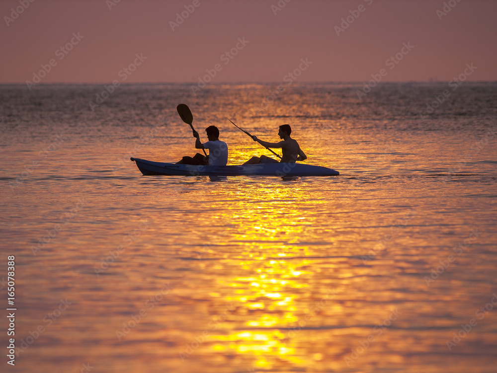 A double kayak in silhouette at sunset on Ko Kut, east Thailand