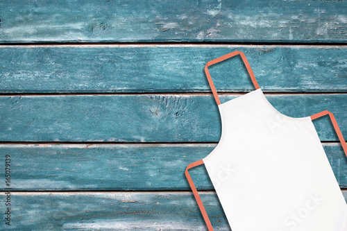 White apron on blue wooden background photo