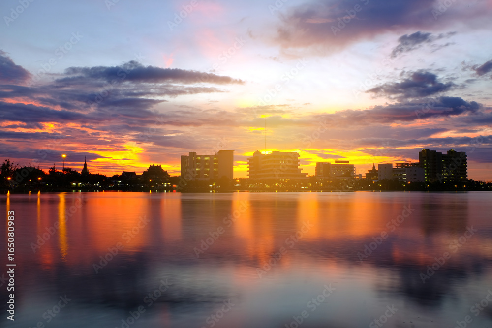 Naklejka premium Sunset by the lake in the city park is the background.