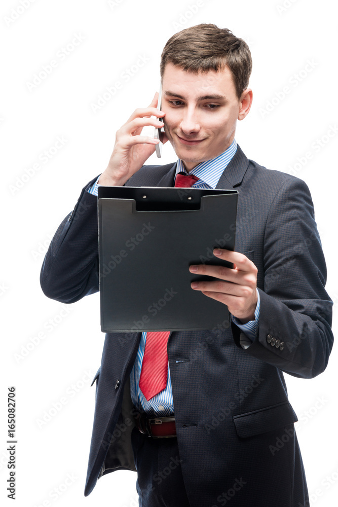 Businessman looking in a folder and talking on the phone on a white background Businessman looking in a folder and talking on the phone on a white background