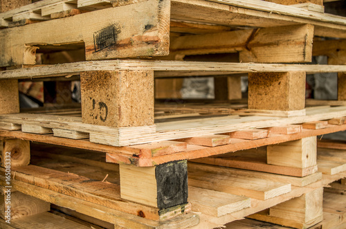 Outside stock of old manufactured wooden standard euro pallets stored in pylons