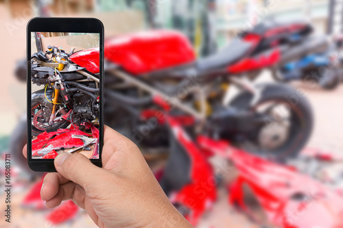 Close up hand  holding smartphone and take photo of motorbike accident photo