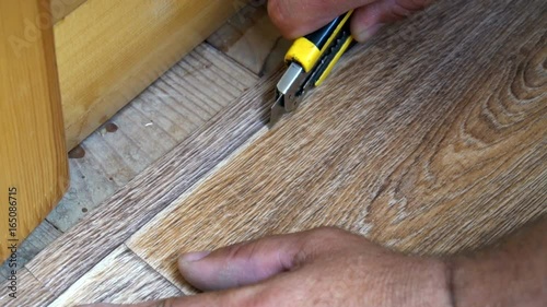 the worker cuts off the linoleum with a utility knife,fitting of linoleum floor.