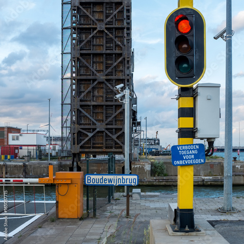 Traffic light in front of a lock (known as 'Boudewijnsluis') and bridge in the Port of Antwerp photo