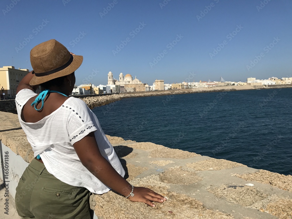 mujer africana contemplando las vistas de la ciudad de Cadiz
