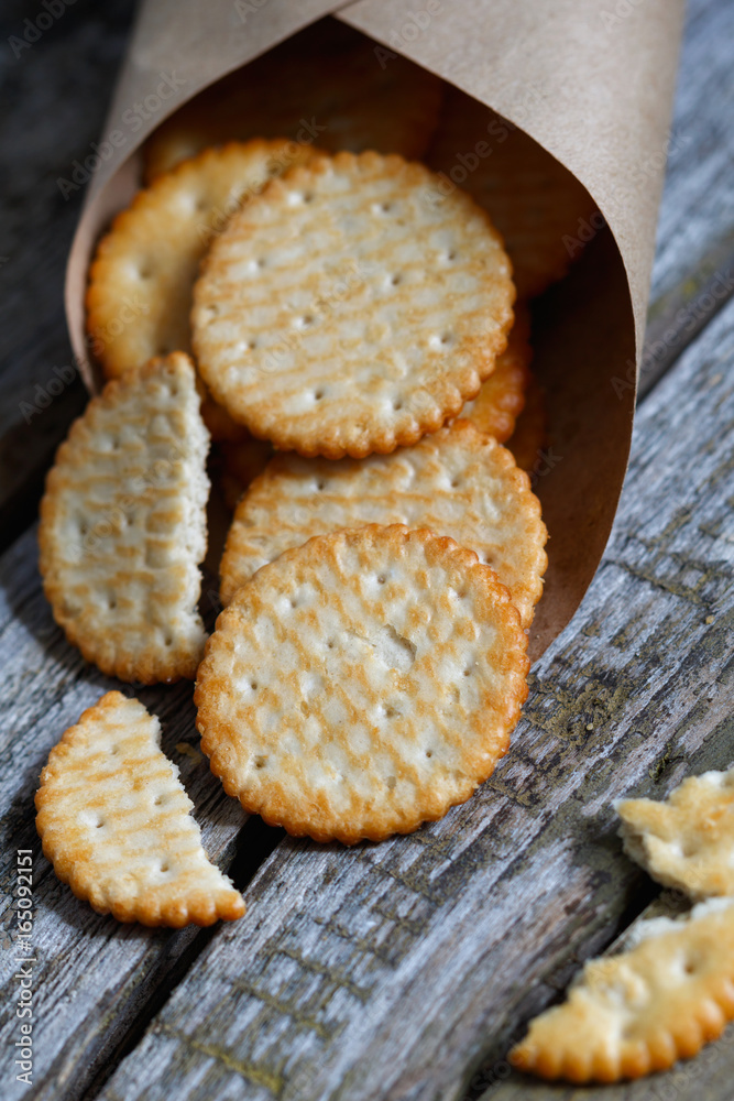 Close-up of a of salted crackers on an old wooden table.