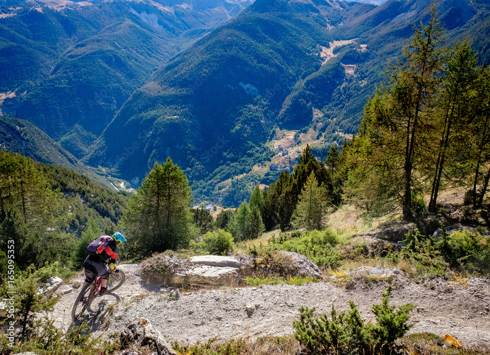 mountain biker turning a corner high above a valley in the Alps mountain biker turning a corner high above a valley in the Alps