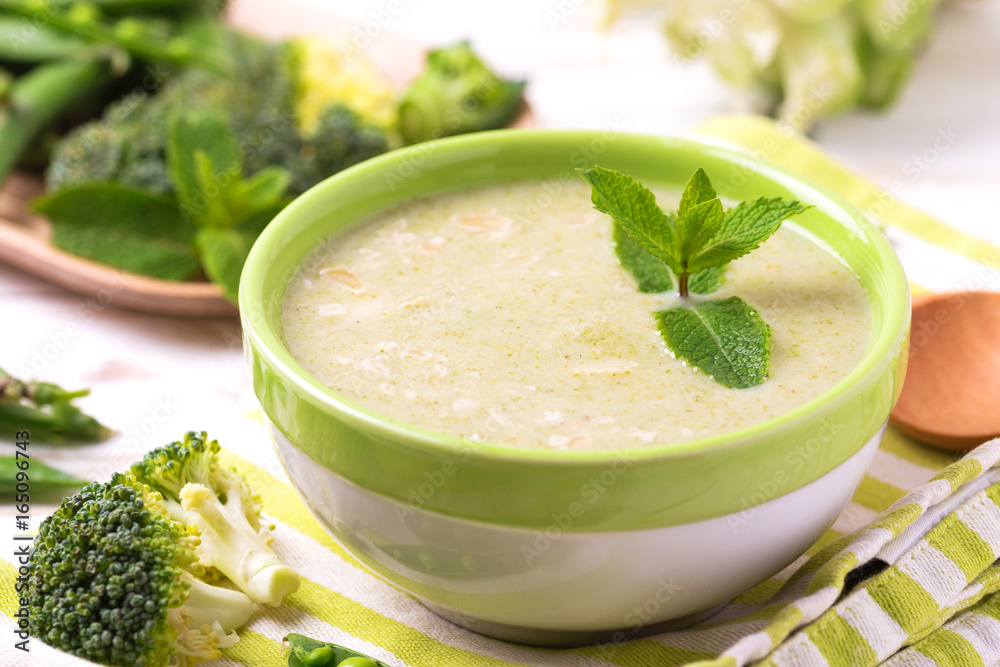 Broccoli and green peas puree soup decorated with mint Broccoli and green peas puree soup decorated with mint