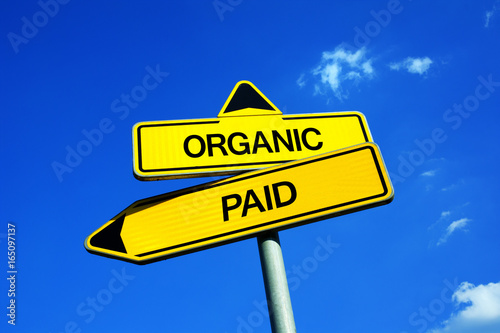 Organic vs Paid - Traffic sign with two options - natural reach of post on social media and network sites vs promote and boost online traffic by commercial marketing