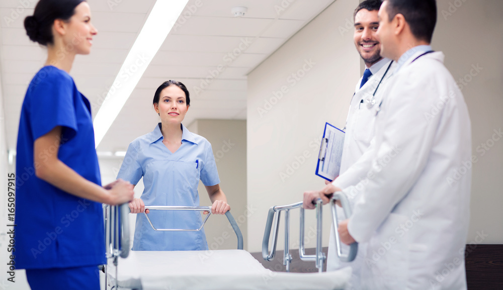 group of happy doctors with gurney at hospital