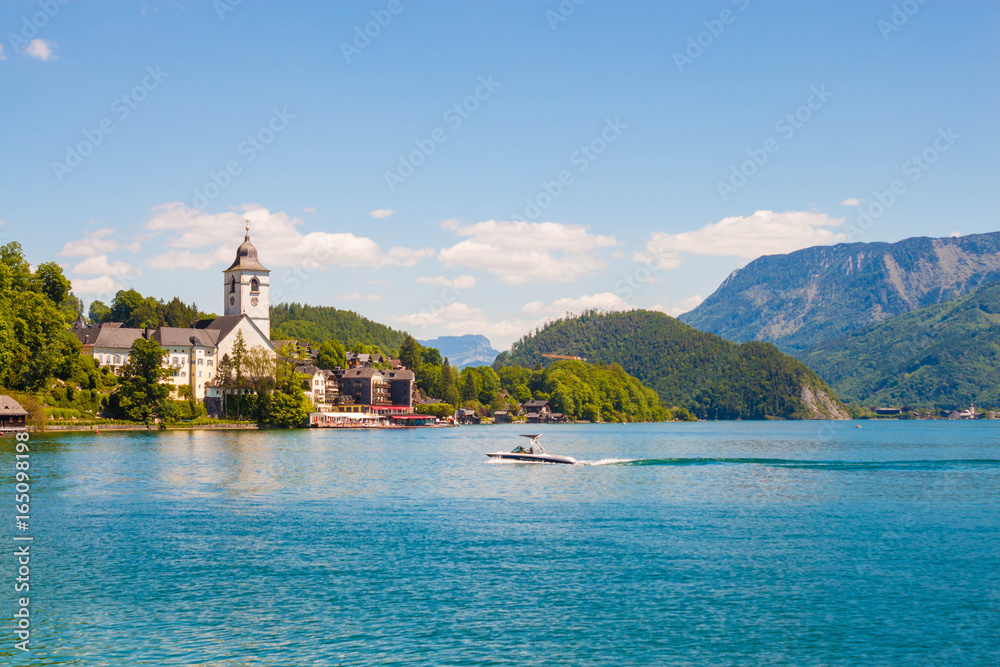 View of St. Wolfgang chapel and the village of St. Wolfgang at Wolfgangsee lake, Austria. Beautiful view of popular touristic austrian town in Salzburg Land.
