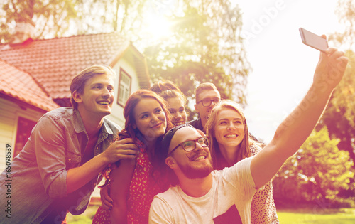 friends taking selfie at party in summer garden