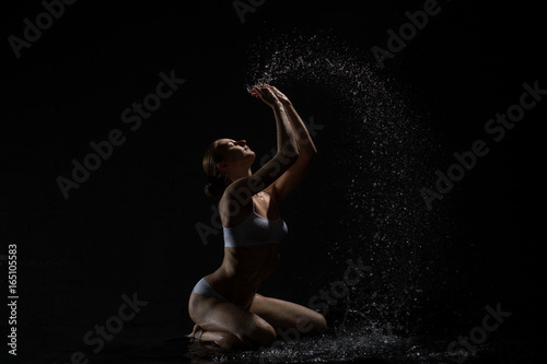 Sexy blonde posing in water and splashes around