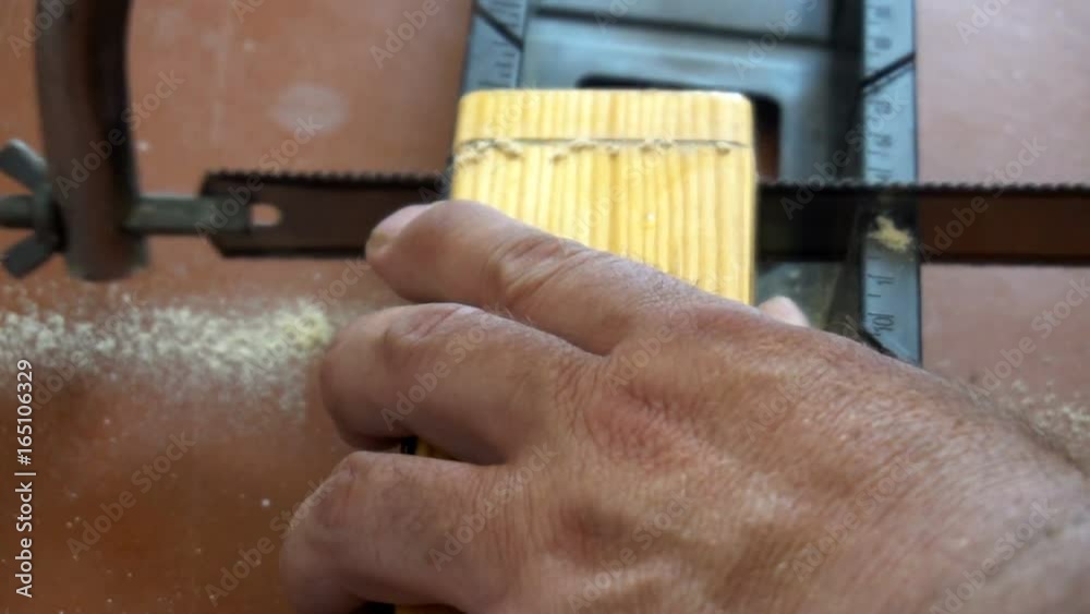 worker sawing with a hacksaw, the wooden bar. worker sawing with a hacksaw, the wooden bar.