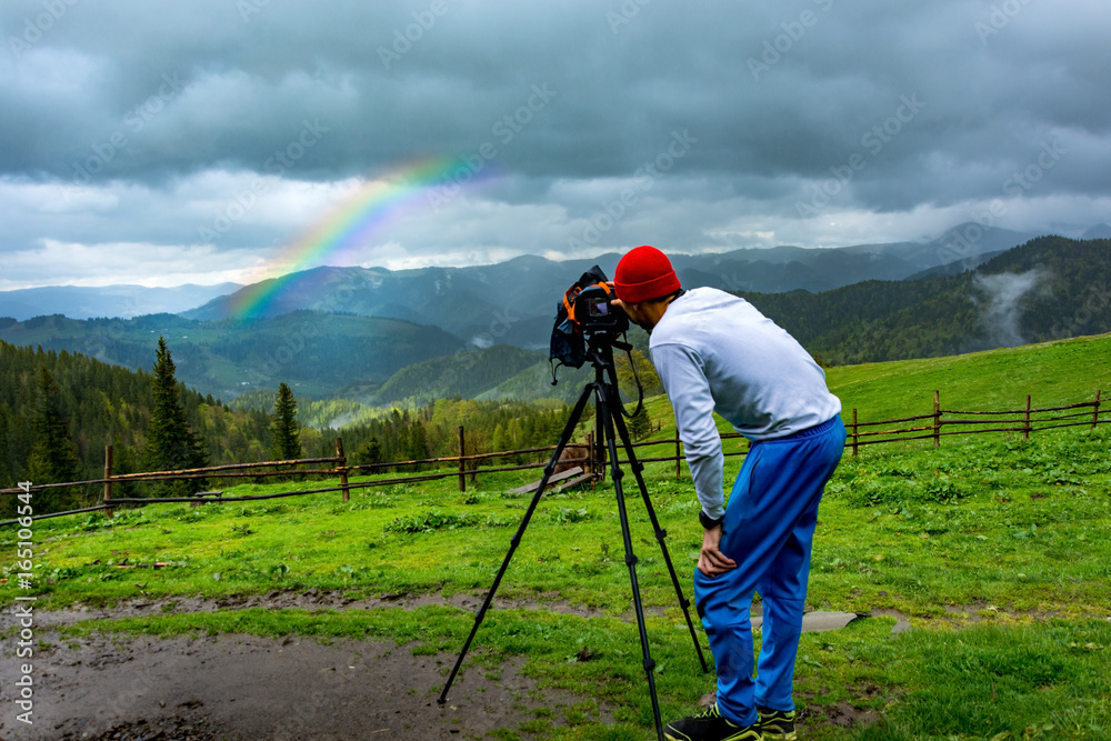 custom made wallpaper toronto digitalBackground, young guy hiker travels photographing a rainbow storm in the spring in the mountains by a photoaparano on a tripod