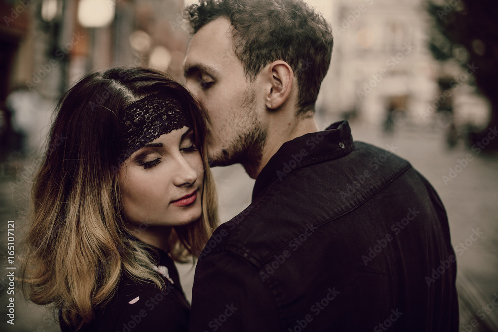 Close-up of a romantic couple kissing, handsome bearded man kissing sensual blonde woman outdoors portrait, passion concept Close-up of a romantic couple kissing, handsome bearded man kissing sensual blonde woman outdoors portrait, passion concept