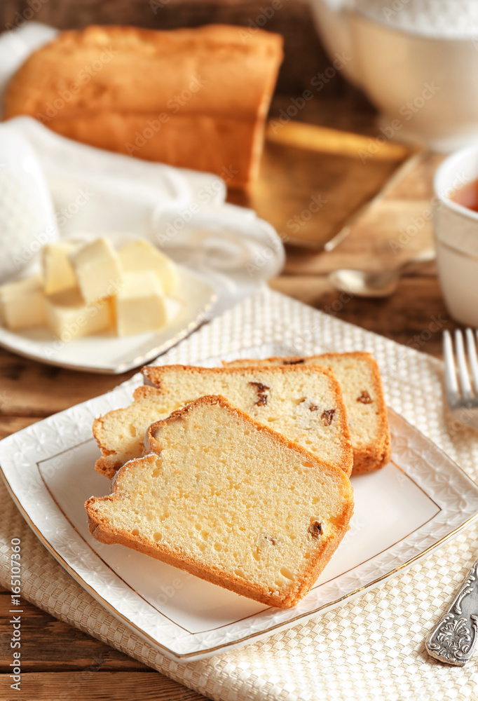 Plate with delicious sliced butter cake on wooden table Plate with delicious sliced butter cake on wooden table