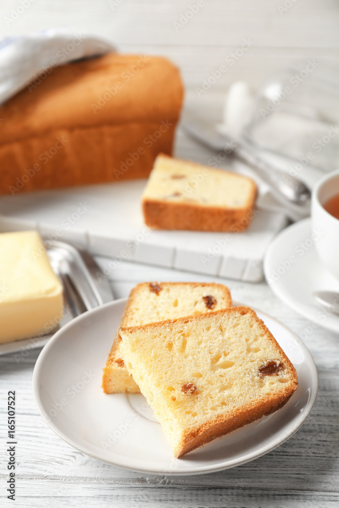 Plate with delicious sliced butter cake on wooden table