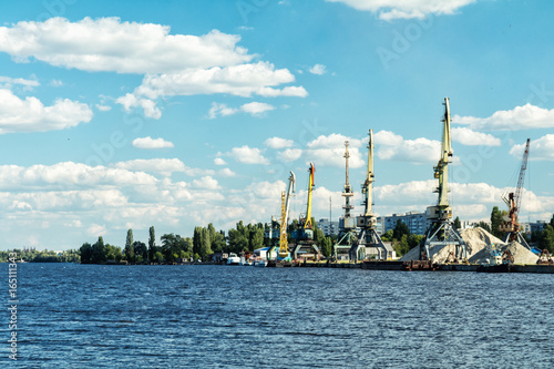 Container cranes in Dnieper river harbor. Loading and unloading cranes in the river port. The river port accepts and ships the cargo across the water.