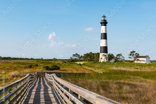 Wooden ramp over marshland leading to an observation point  with the the Bodie Island lighthouse in the background  on the Outer Banks of North Carolina near Nags Head.  