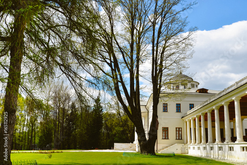 Nice view on Ostafyevo palace in Moscow region and public park. Antique mansion 18-19 century in classicism style. Beautiful landscape with old manor, lawn, sky and trees for wallpapers, prints. photo