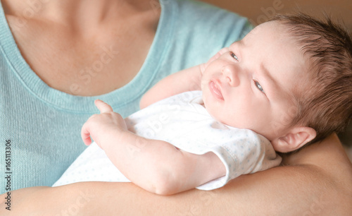 Happy young woman holding her newborn baby boy, closeup