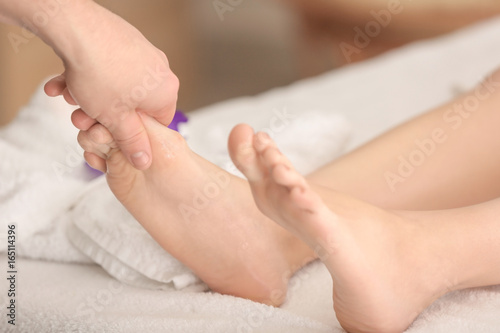 Young woman having foot massage in spa salon, closeup