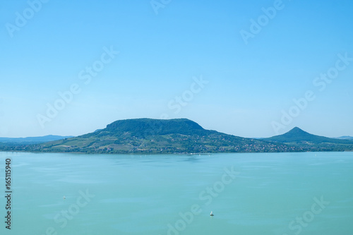 sailboat on water  fameus Badacsony hill in background - summertime and vacation at Balaton lake