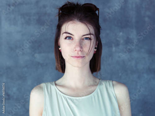 Portrait of a young beautiful woman, blue background