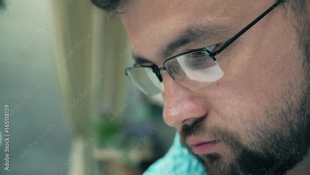 Close up of young man reading his tablet in the dark. background. 4k Close up of young man reading his tablet in the dark. background. 4k