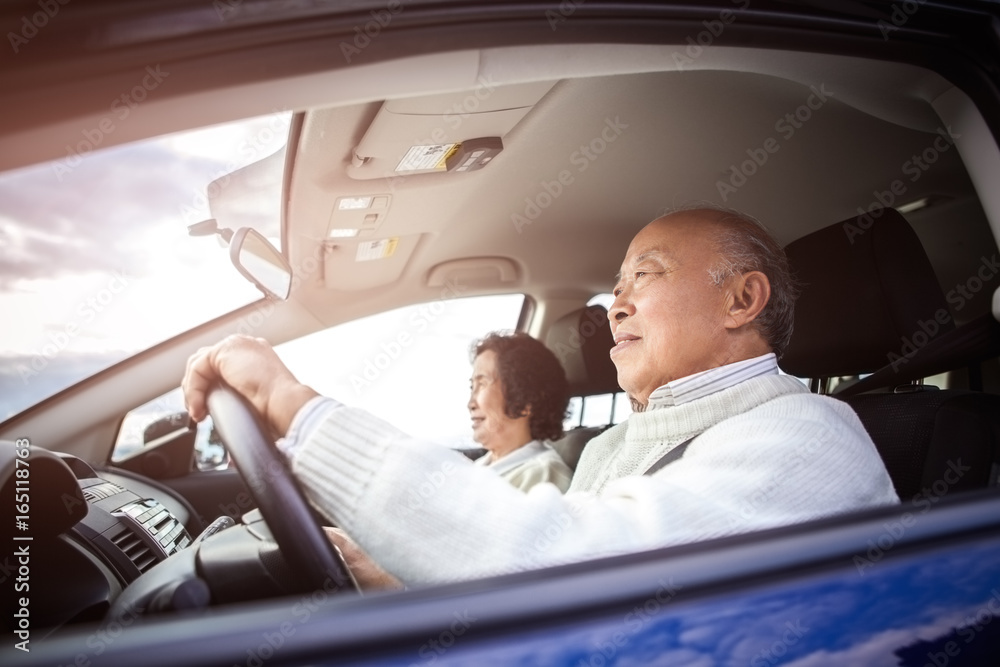 Traveling senior Asian couple driving and riding in a car Traveling senior Asian couple driving and riding in a car