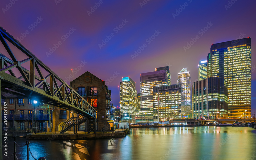 London, England - The skyscrapers of Canary Wharf financial district and residential buildings at the docklands of London by night