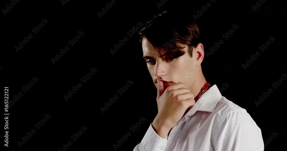 Androgynous man posing against black background Androgynous man posing against black background