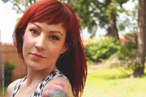 Smiling Young Redhead with Tattoos Outside photo