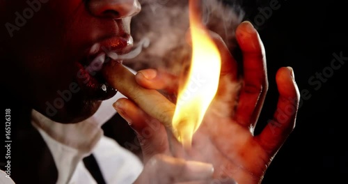 Androgynous man lighting a cigar photo