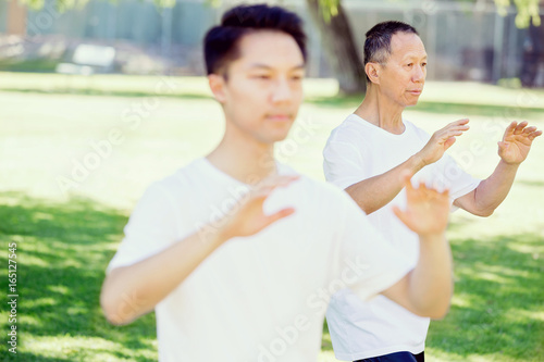 People practicing thai chi in park