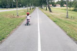 Little girl riding bike on lonely road 