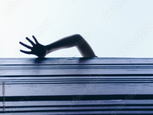 Child hand reaching blue sky 