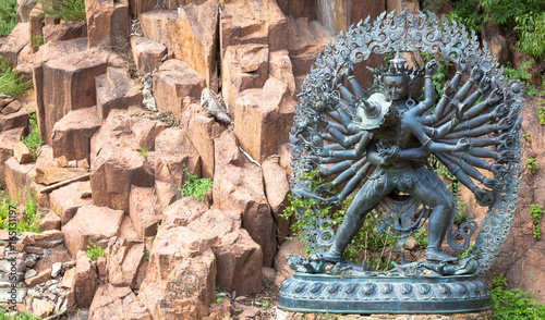Tantric Deities statue in Ritual Embrace located in a mountain garden