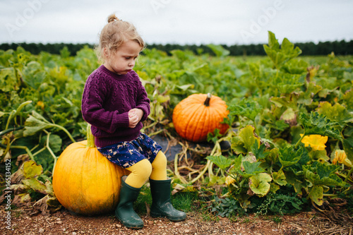 little girl pouting in a pumpkin patch