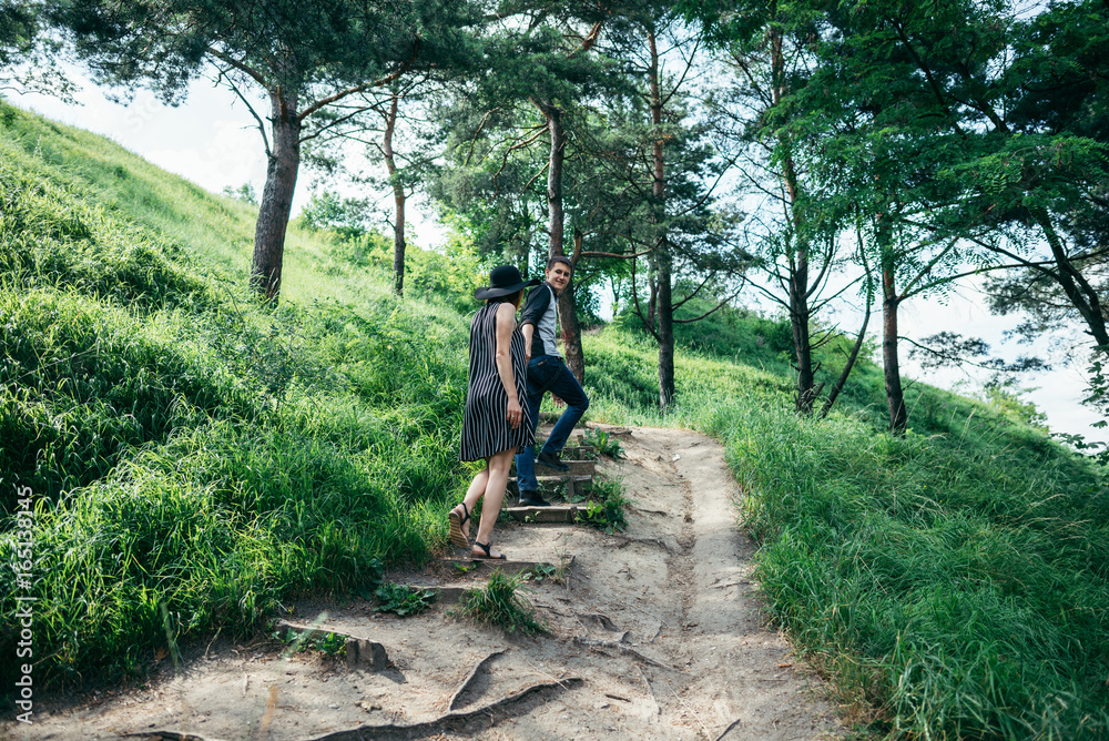 lovely couple climbing up by forest trail lovely couple climbing up by forest trail