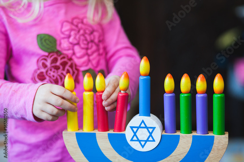 Child playing with toy Menorah. photo