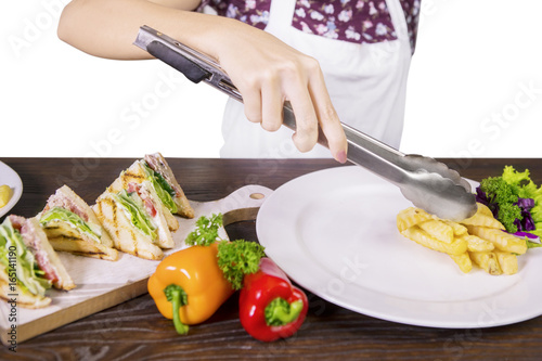 Female chef preparing sandwich