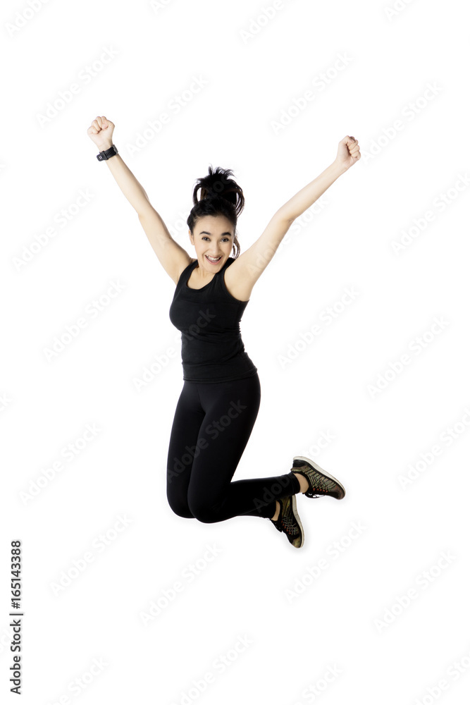 Middle eastern woman jumping in the studio